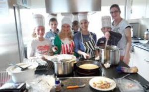 Scholieren bakken pannenkoeken voor ouderen