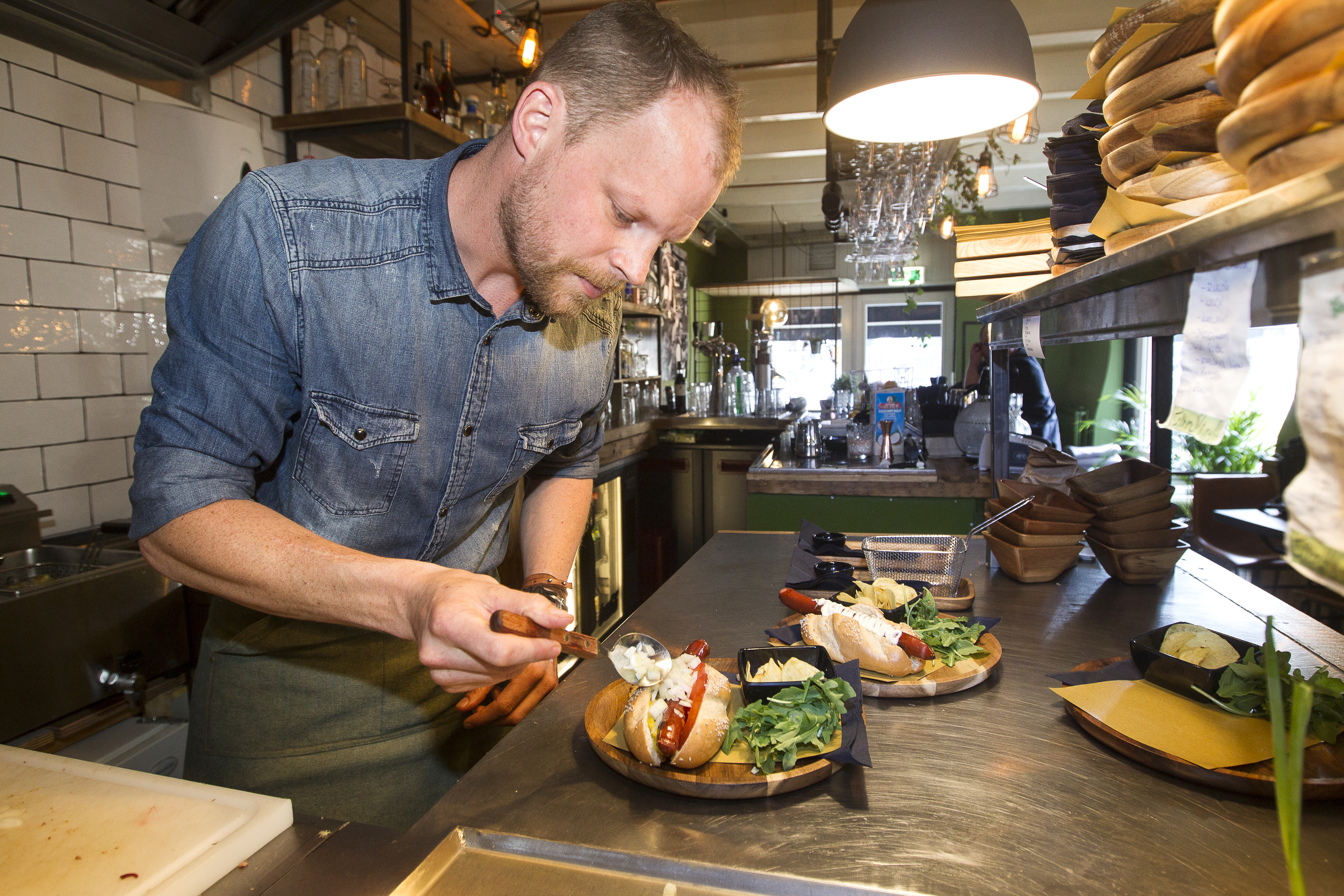  Rolf Dingerink, de kersverse eigenaar van Dogtails in Zwolle, gefocust op zijn hotdogs. Foto Hissink.