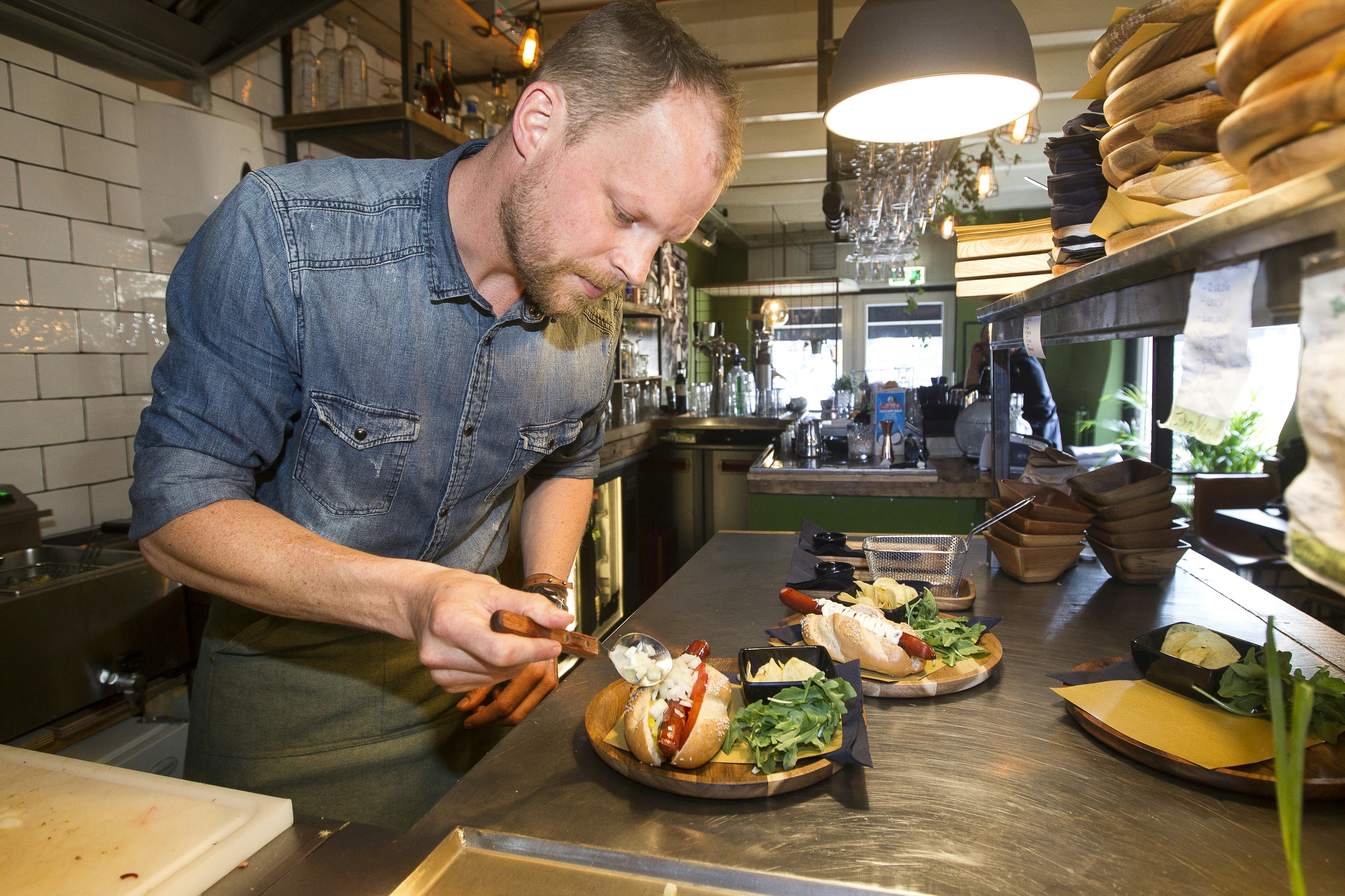Rolf Dingerink, de kersverse eigenaar van Dogtails in Zwolle, gefocust op zijn hotdogs. Foto Hissink.