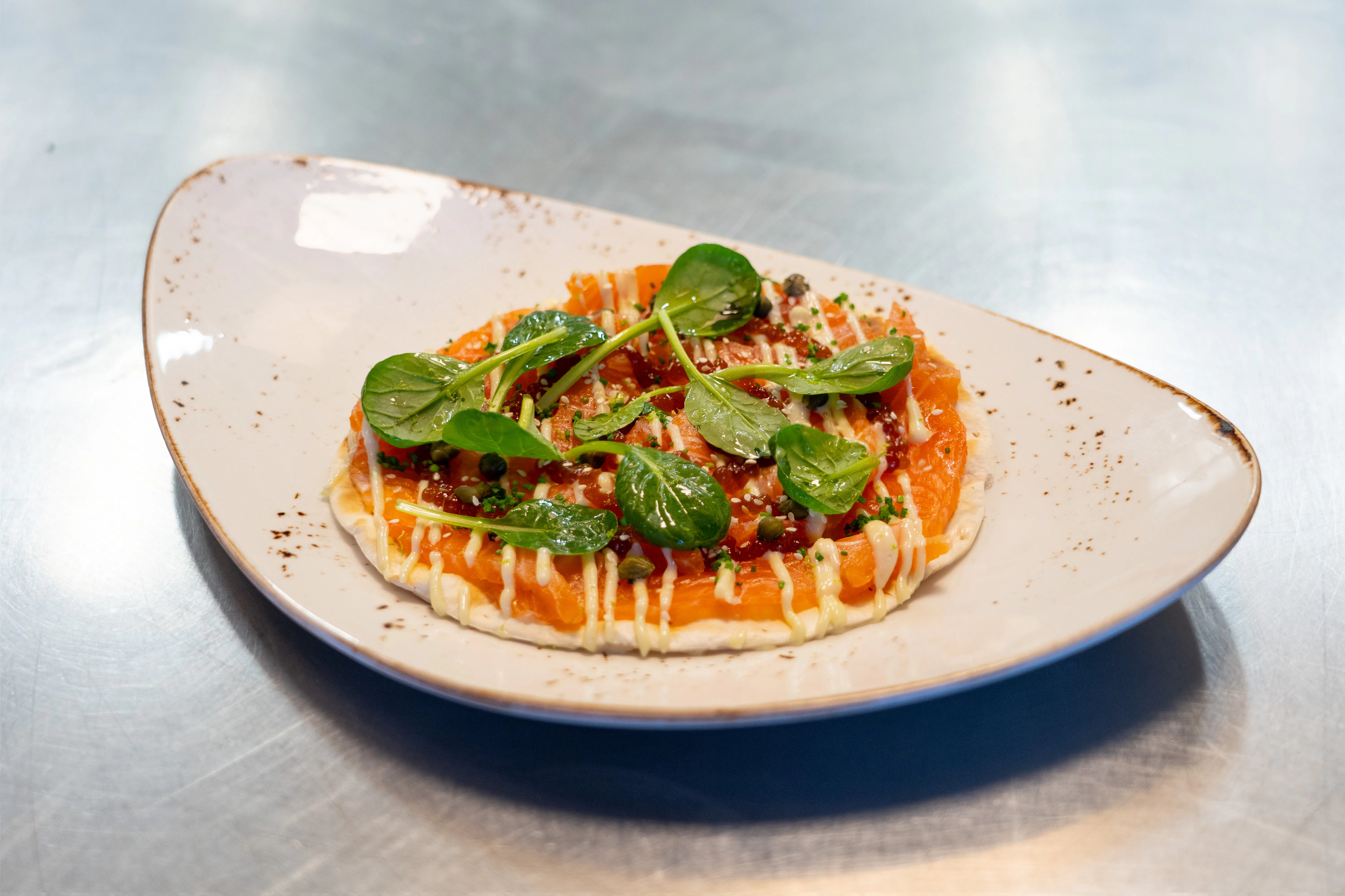 Krokante pizza van flammkuchen, gerookte zalm en wasabi mayonaise. Foto: Jan Willem Schouten