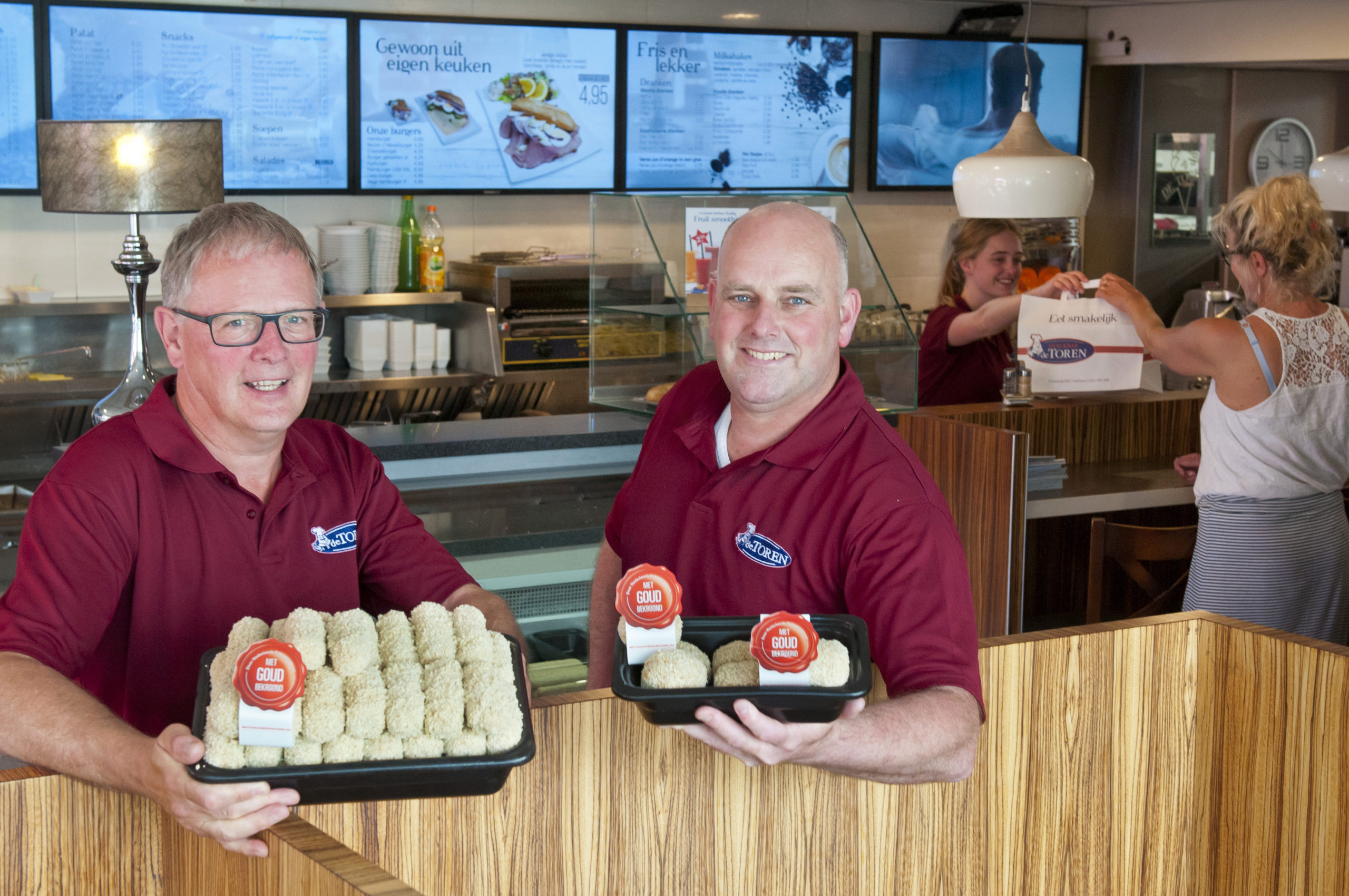 Ronald Meijer (links) en Arjan de Winter van De Toren in Castricum met hun gouden snacks. Foto: Wick Natzijl