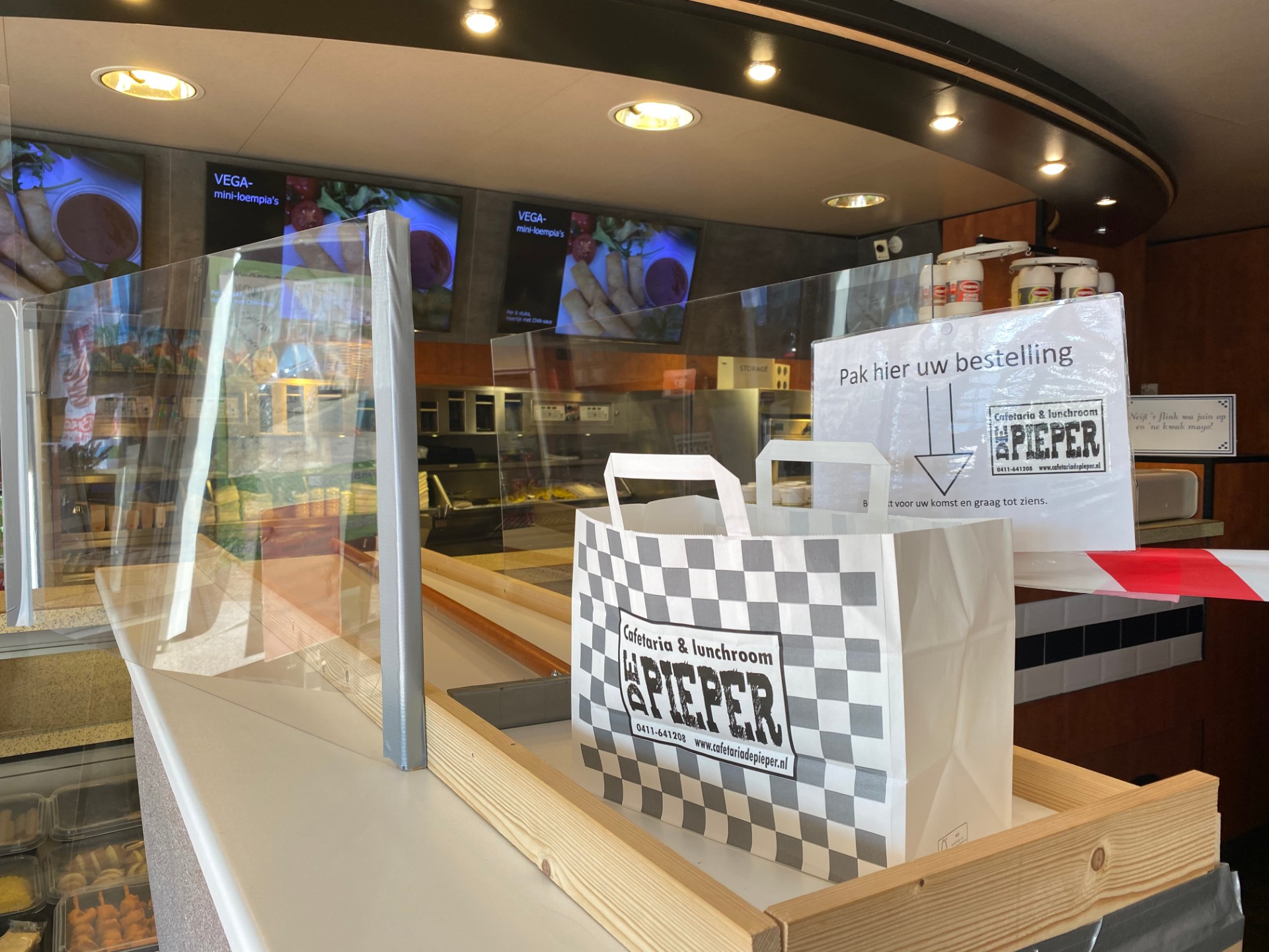 Een voorbeeld van creatief ondernemen in coronatijd: cafetaria de Pieper in Helvoirt heeft een soort curlingbaan gebouwd waar bestellingen overheen gaan om de afstand tussen medewerkers en klanten te borgen. 