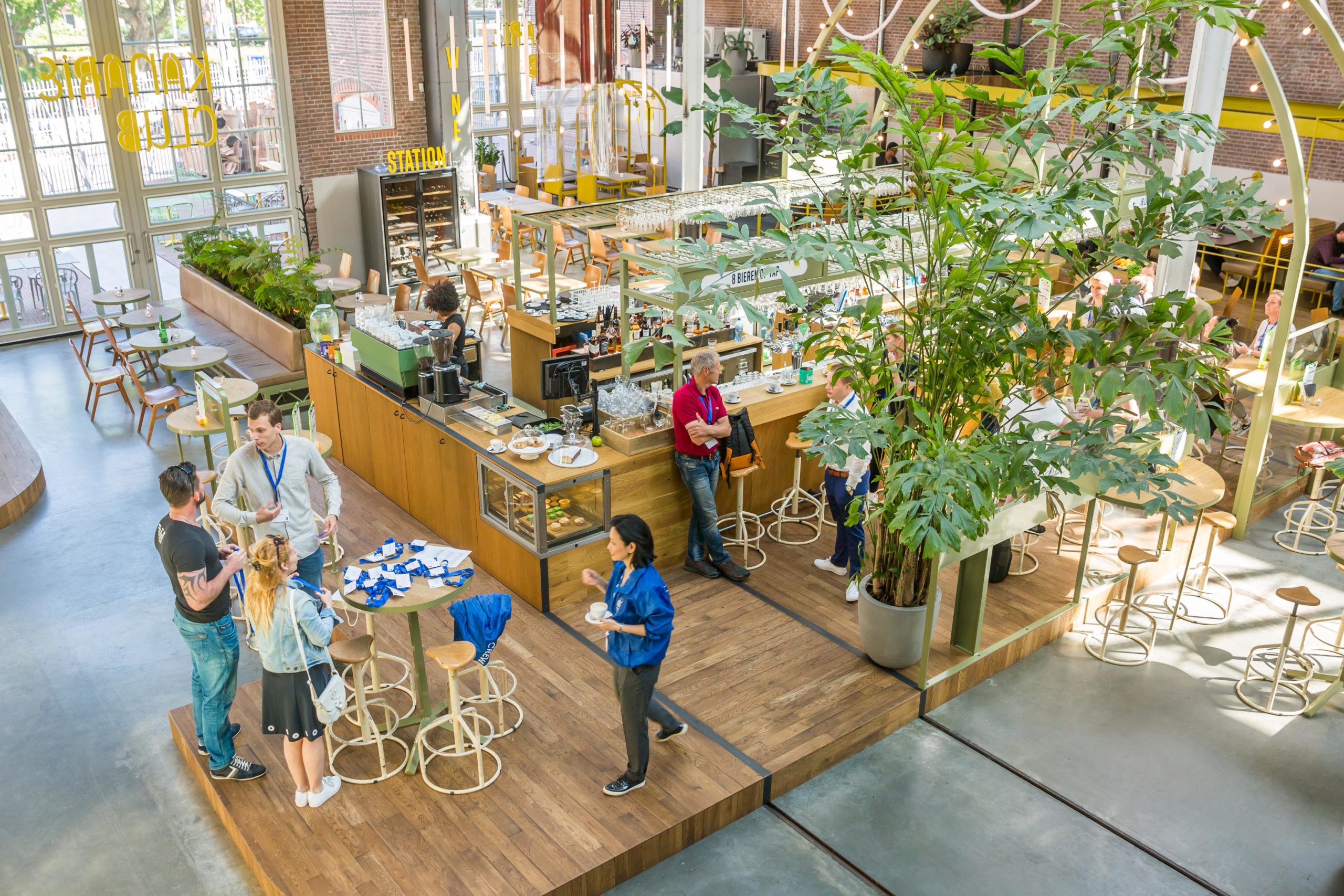 Ook in de Foodhallen: de Kanarie Club, waar gasten de hele dag terecht kunnen voor eten en drinken. Dit staat misschien ver af van de cafetariabranche, maar ook in deze tak van de horeca moet een bedrijf op verschillende momenten op een dag in een behoefte voorzien. Zo biedt de Kanarie Club een werkomgeving voor zzp-ers, een drie- of vijfgangendiners op niveau en in de weekenden cocktails en dansmuziek.  