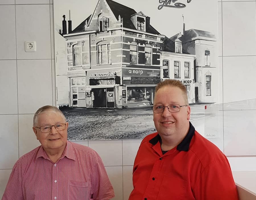 Ton Norp met zijn vader Anton voor het zwart-wit tafereel van het pand uit 1951, gemaakt door bevriend kunstenaar Dick Dekker.  