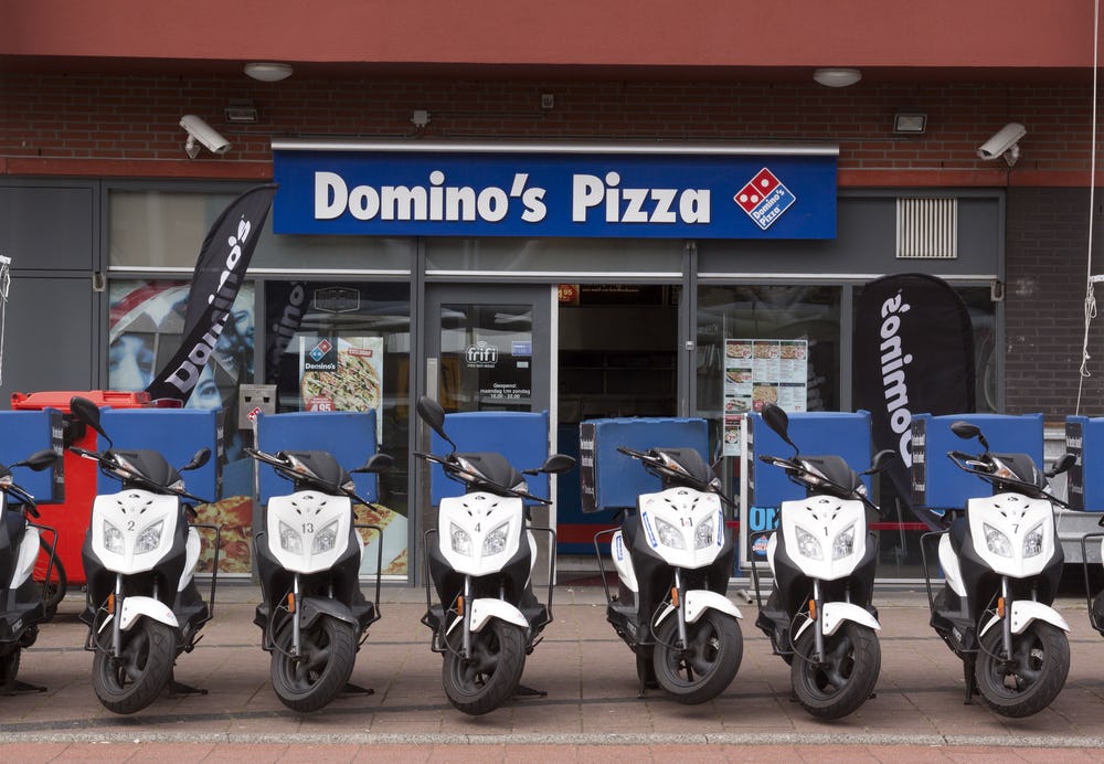 Een vestiging van Domino's Pizza in Den Haag. De bezorgscooters moeten in 2020 allemaal  zijn verdwenen. 