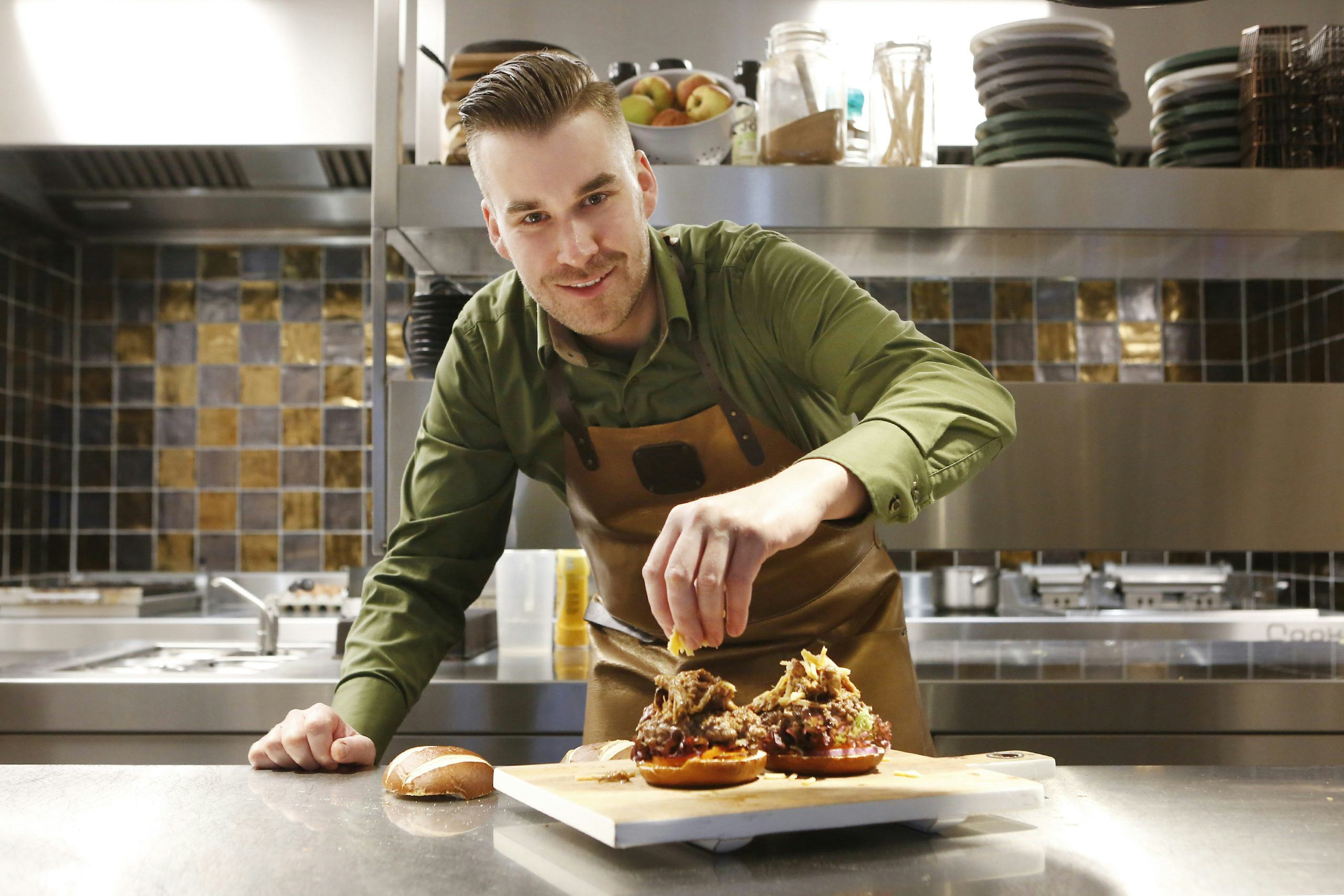 Vincent Kuik werkt aan een hamburger met pulled pork. © Studio Kastermans -Daniëlle van Coevorden. 