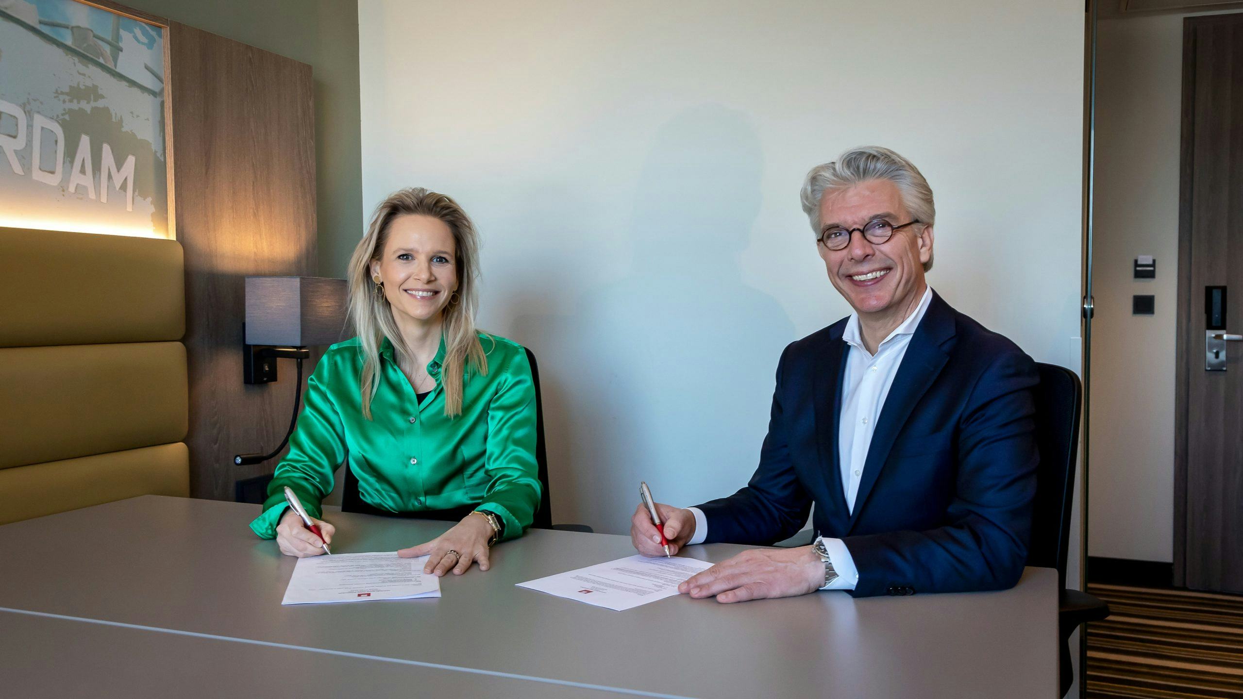 Annelou de Groot van IWG (links) en Alexander Kluit van Leonardo Hotels (rechts) tekenen de samenwerking. Foto: Photo Republic/Bibi Neuray