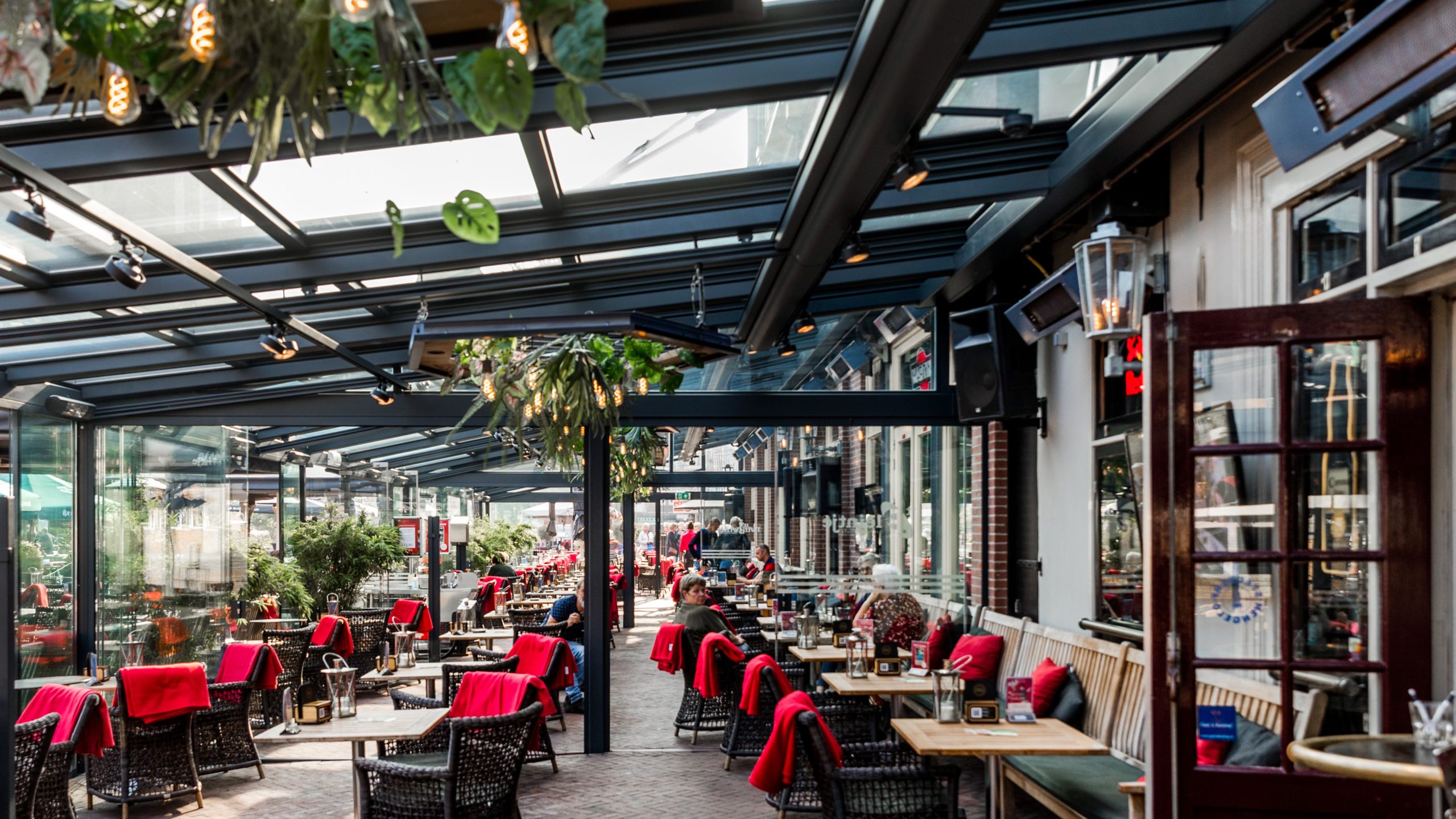 De Twee Wezen in Hengelo is de terrasoverkapping van glas. Het dak is volledig open te schuiven. Foto en leverancier terrasoverkapping: Horeca Zonwering Nederland.