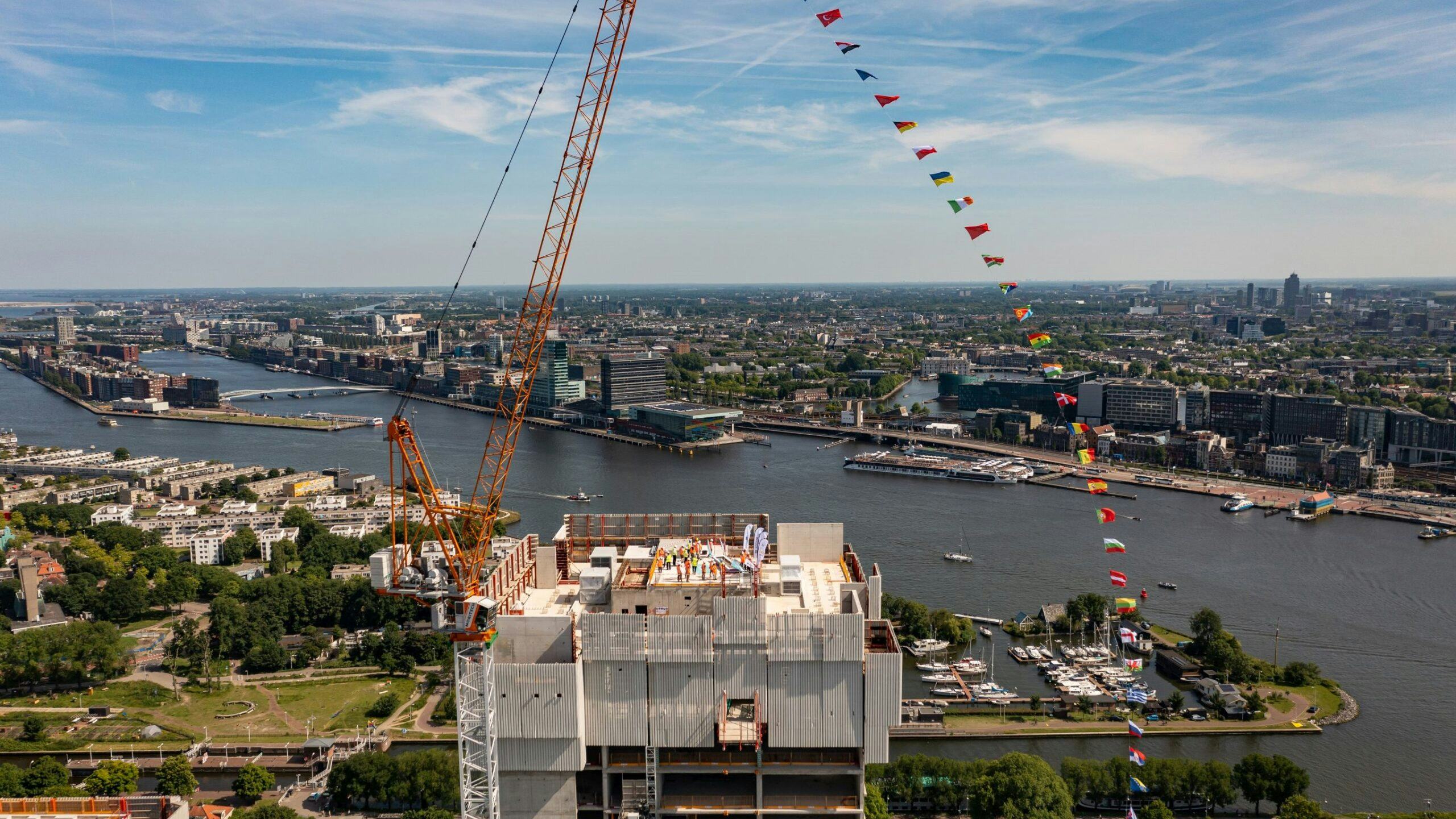 De 34 vlaggen die werden gehesen bij het bereiken van het hoogste punt van Maritim Hotel Amsterdam symboliseren de 34 nationaliteiten die betrokken zijn bij de bouw van het megahotel.