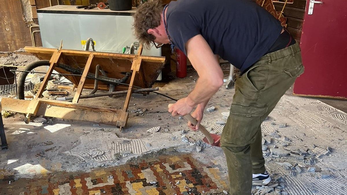 Tim Immers bezig met renovatie van de tegelvloer.