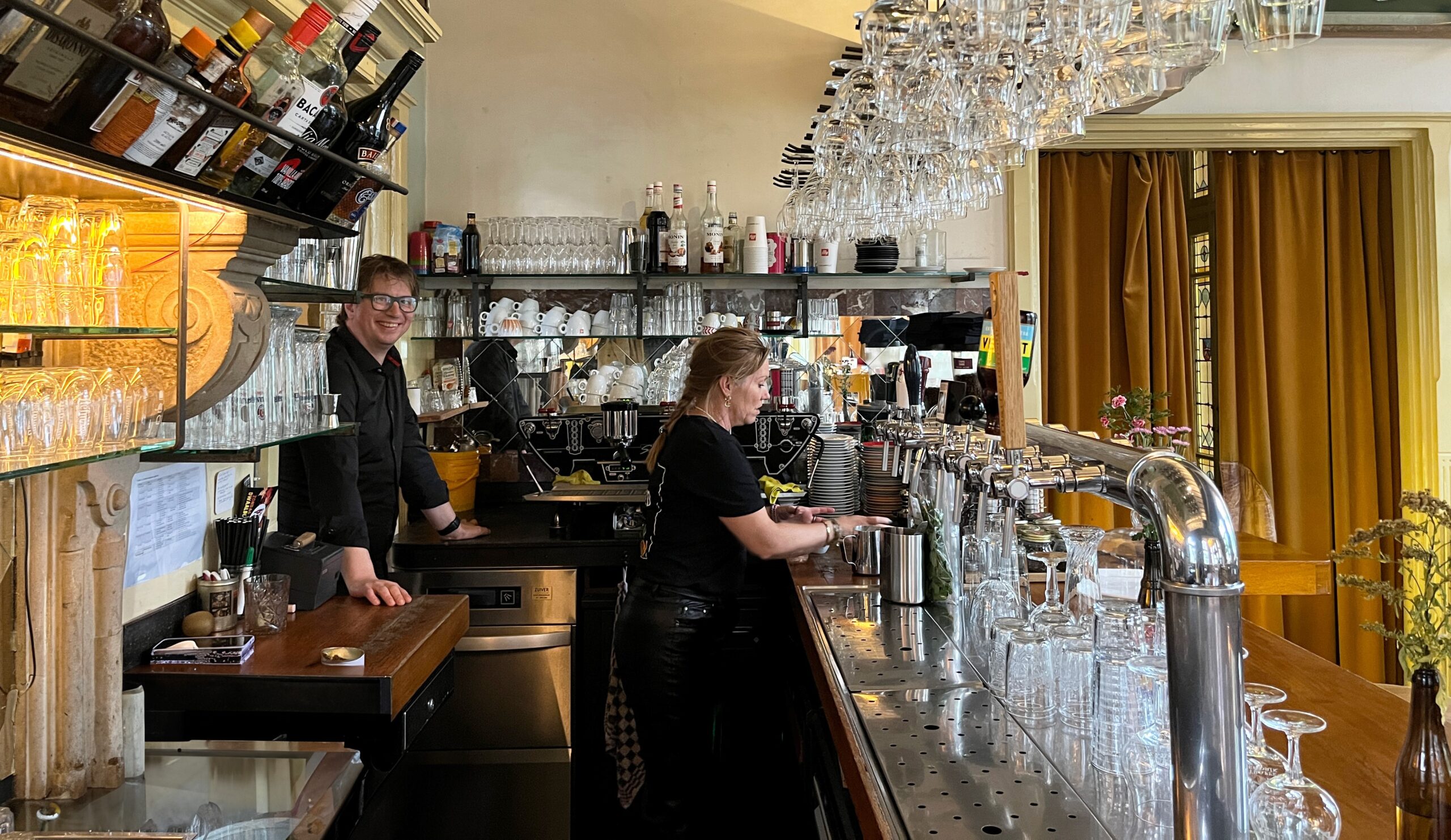 Eigenaar Erik Wannemakers staat met Monique van der Poel achter de bar bij De Spaarbank: 'De hele dag door genieten mensen van onze koffie, en ze komen er telkens voor terug.'