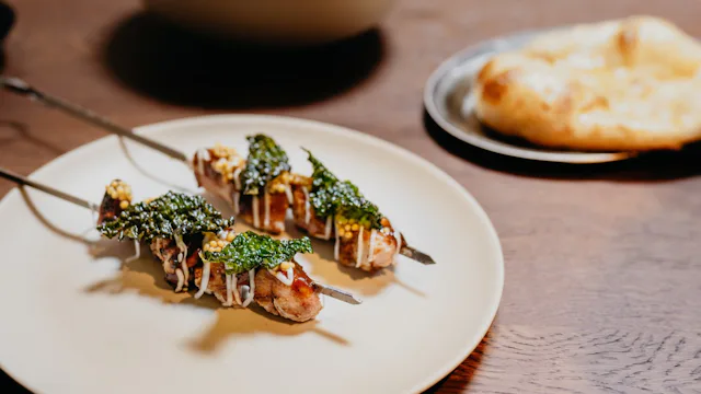 Souvla van zwezerik van de BBQ met palmkool, laurier en lak van eigen jus.