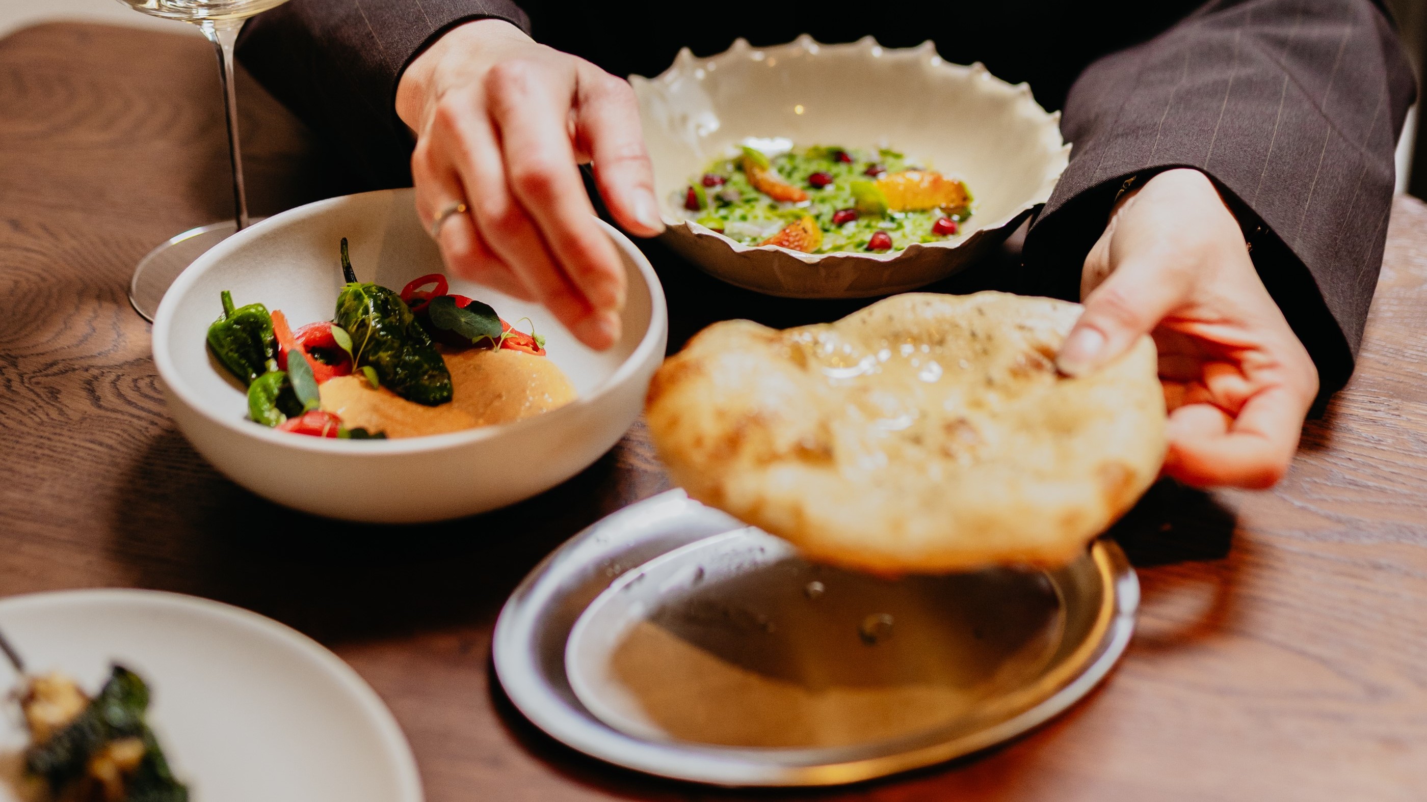 In ‘family style’ geserveerde dips en gerechten met pita uit de steenoven.